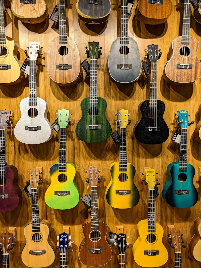 Vibrant ukuleles in various colors hanging on a wooden wall, showcasing musical diversity.